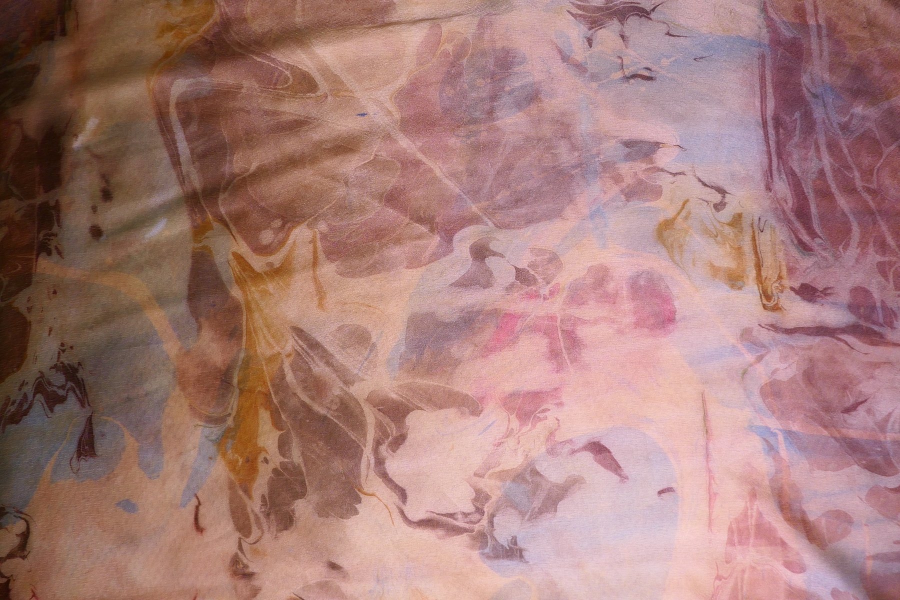 Close-up detail of marbled silk in soft peach and rose tones