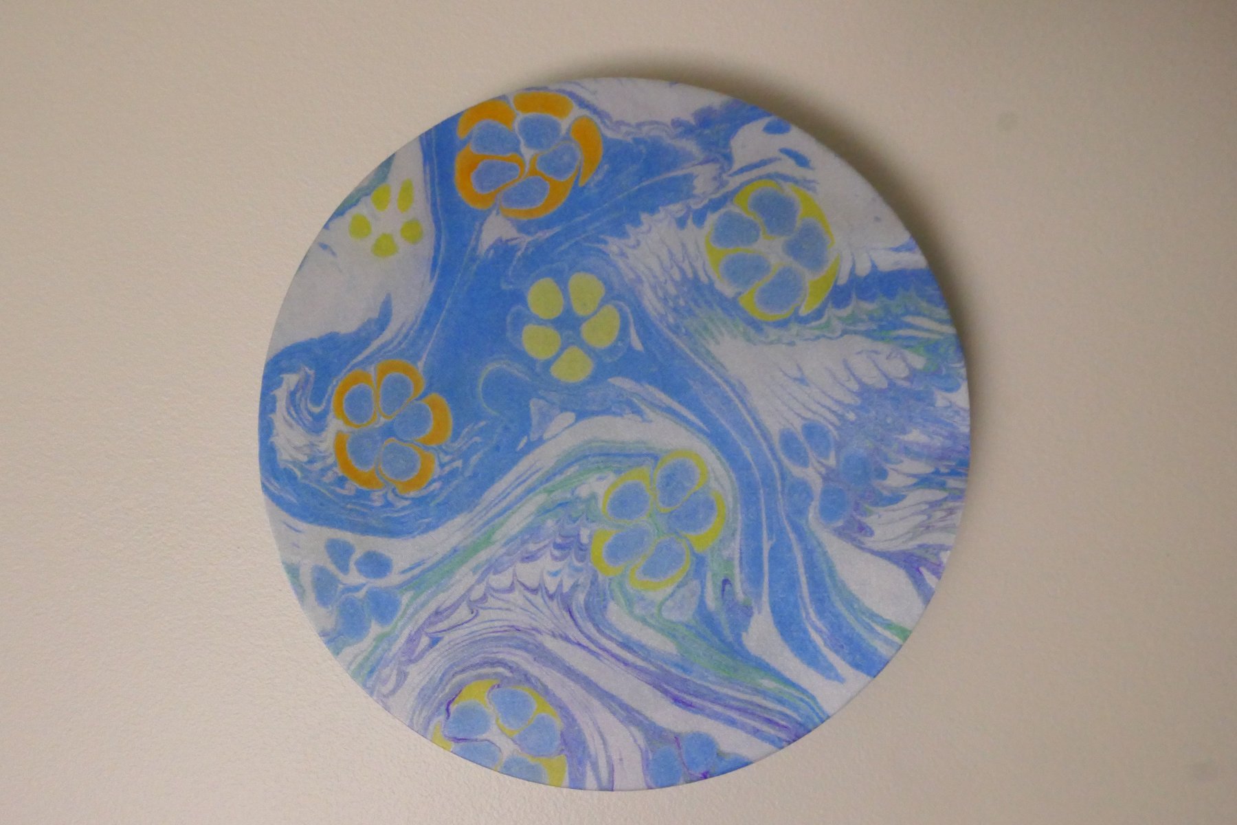 Round marbled wall panel with traditional hatip flower motifs in blue, gold, and yellow